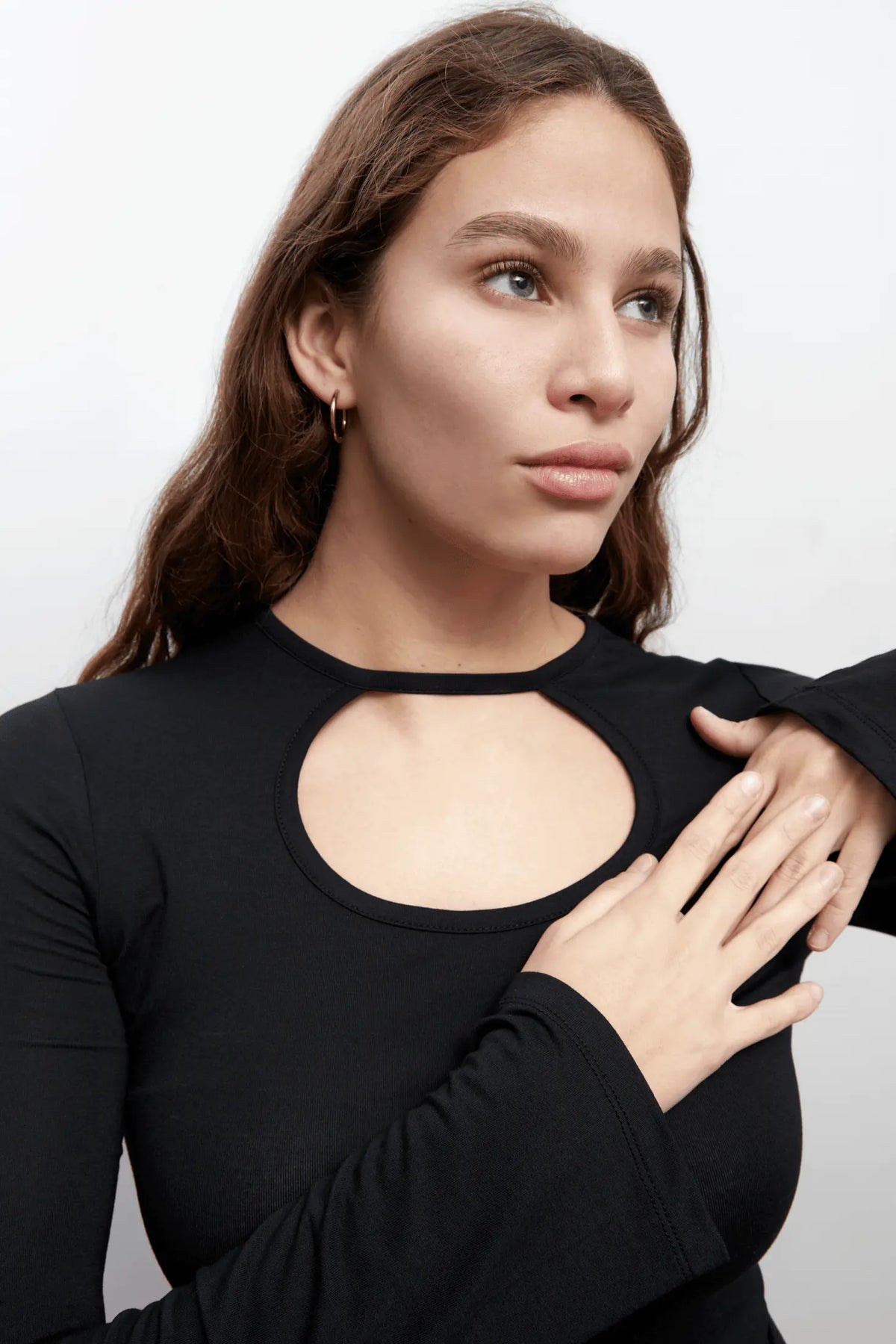 Close up of a model wearing an everyday long sleeves black top with a rounded cut-out. The top is made with Tencel™Modal fabric.