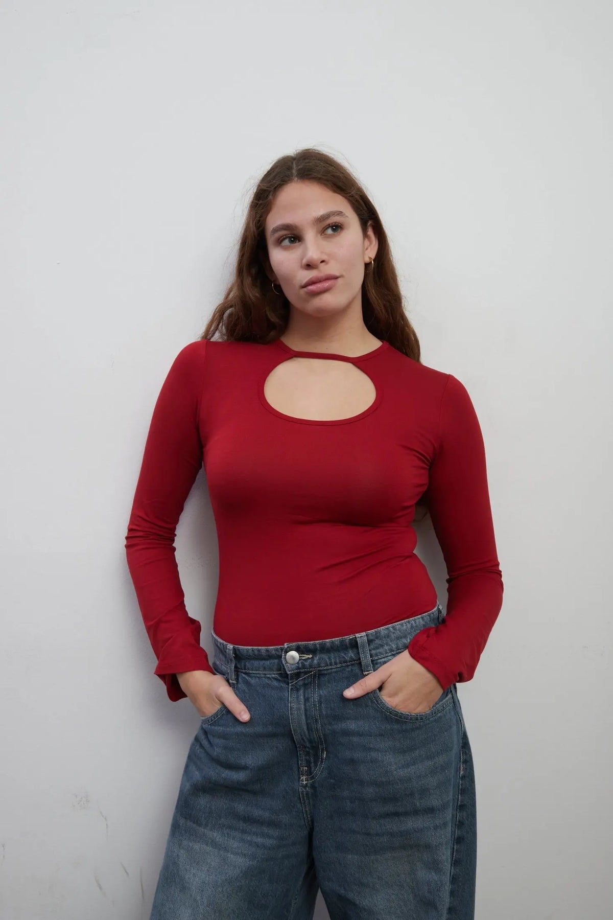Model wearing an everyday soft long sleeves red top with a rounded cut-out. The top is made with Tencel™Modal fabric.