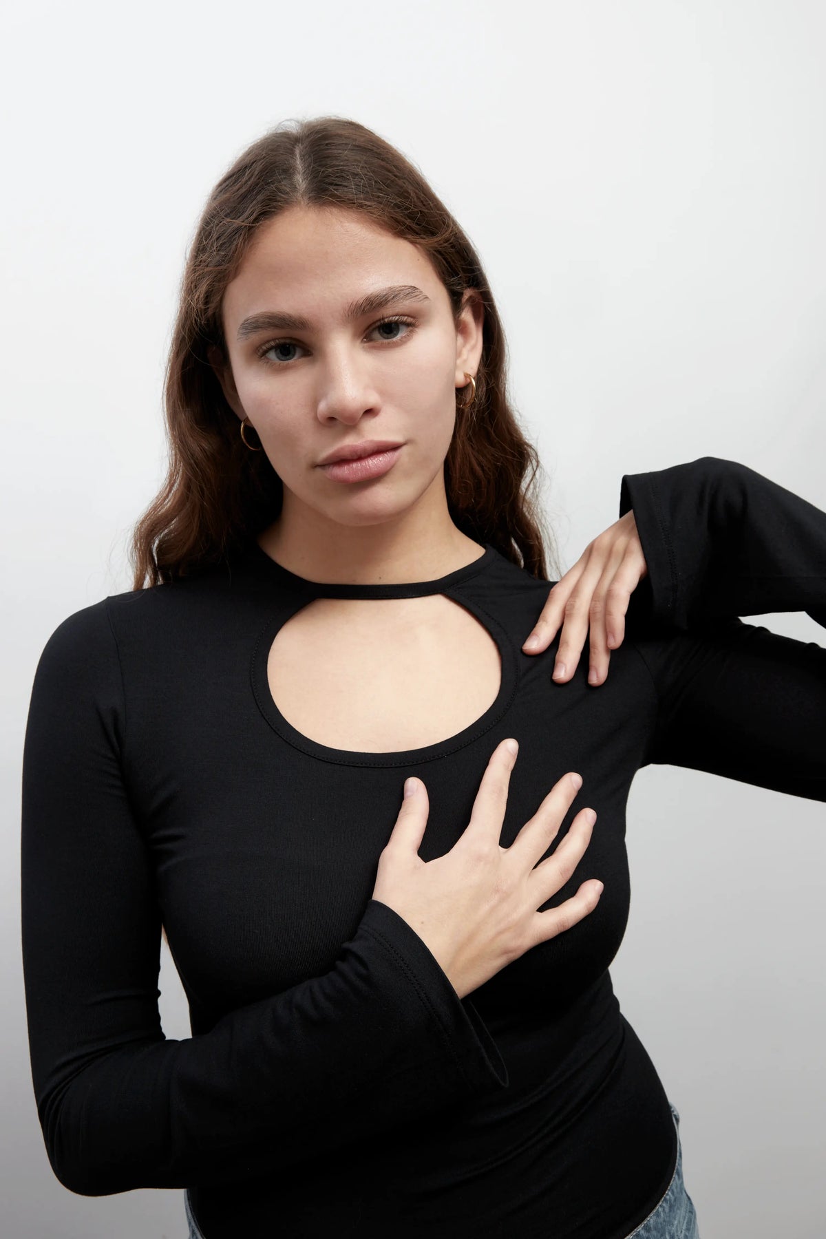 Close up of a model wearing an everyday soft long sleeves black top with a rounded cut-out. The top is made with Tencel™Modal fabric.
