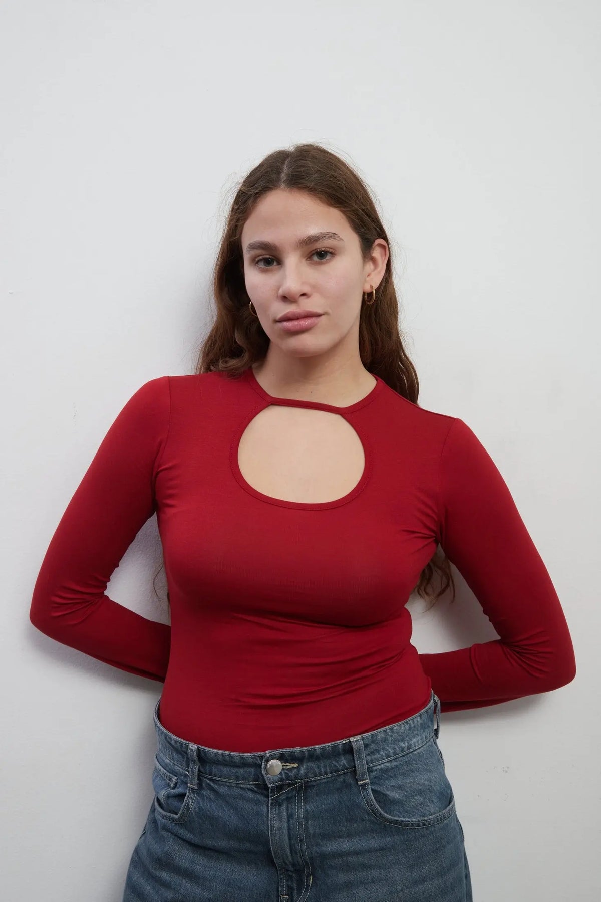Close up of a model wearing an everyday soft long sleeves red top with a rounded cut-out. The top is made with Tencel™Modal fabric.